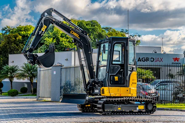 Mini escavadeira DIEL DE35MP em vista lateral dianteira, com a lâmina frontal abaixada