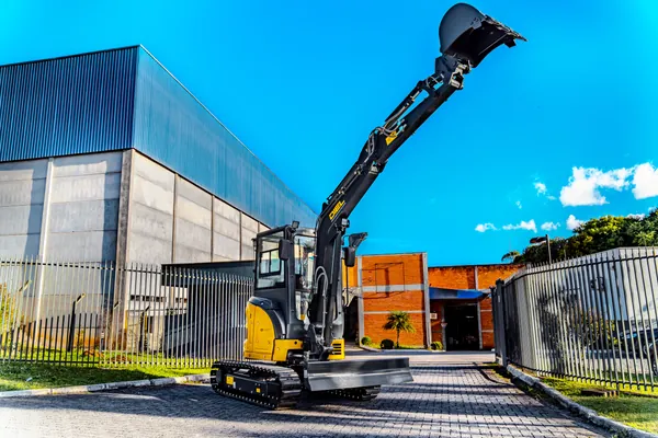 Mini escavadeira DIEL DE35MP com o braço estendido para cima, em vista ampla